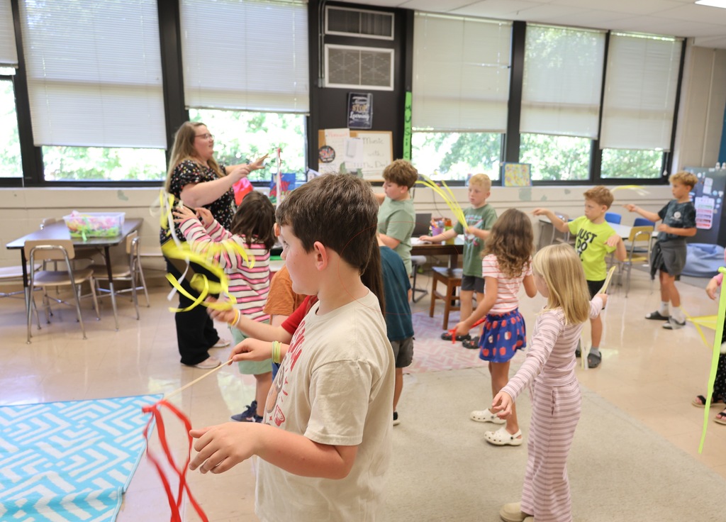 Students participate in a music lesson at Haynesfield Elementary, using colorful ribbon wands to practice conducting, rhythm, and beat as their teacher leads the activity.