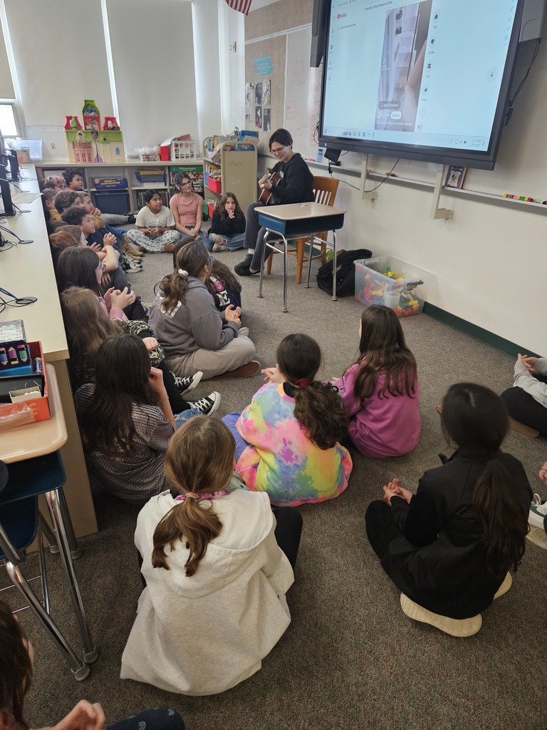 Students watching person play guitar