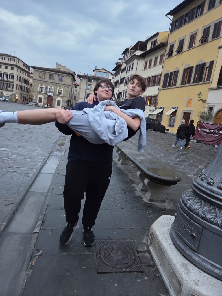 One student carrying another through a European street