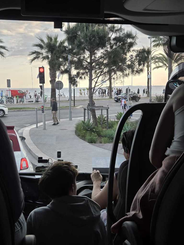 A student makes a presentation in Nice, with the Mediterranean Sea in the background