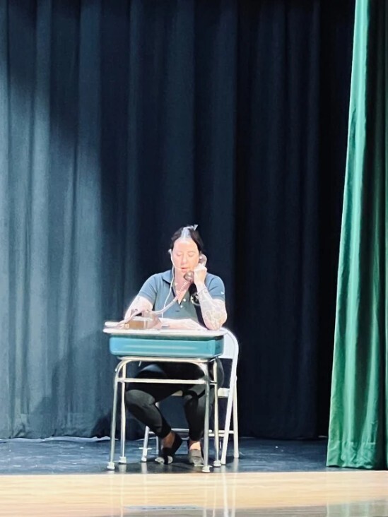 person on stage making phone call