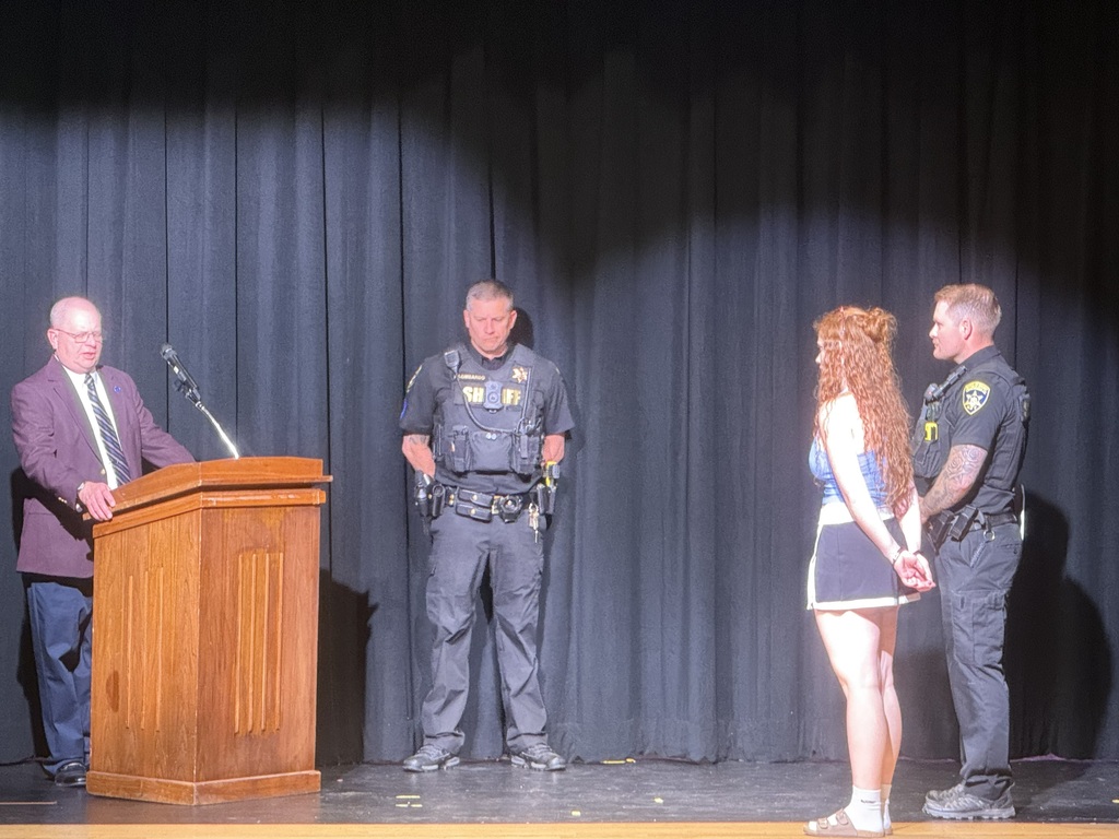 deputies, judge and student on stage speaking