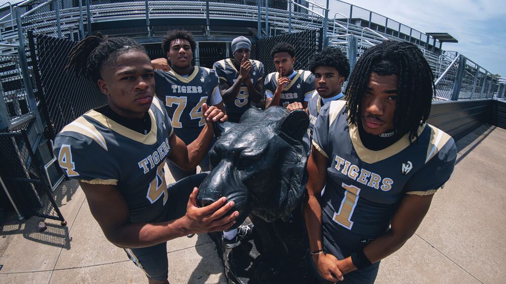 BA football players posing by Tiger statue