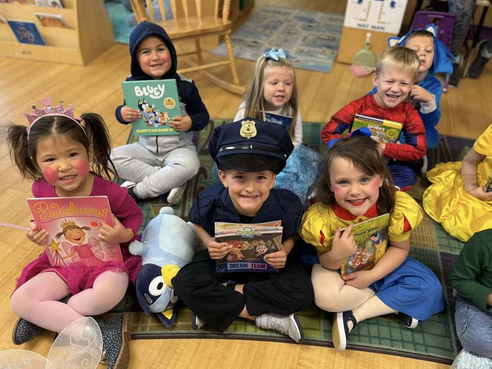 Pre-K students showing their books that they have.