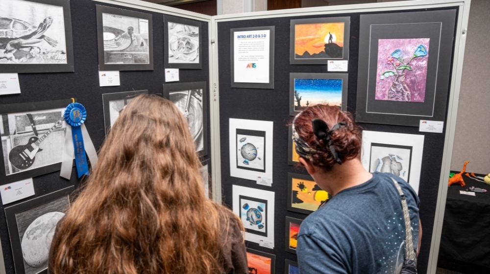 Two students looking at wall art.
