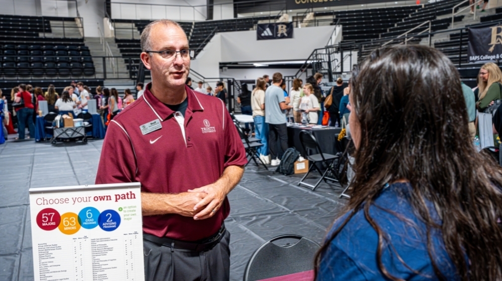 Representative from a college talking with a student.
