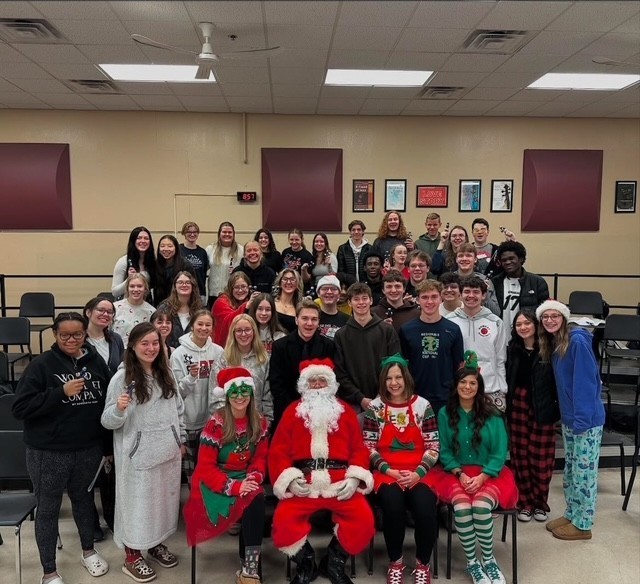 Image of high school chior with santa and elves.