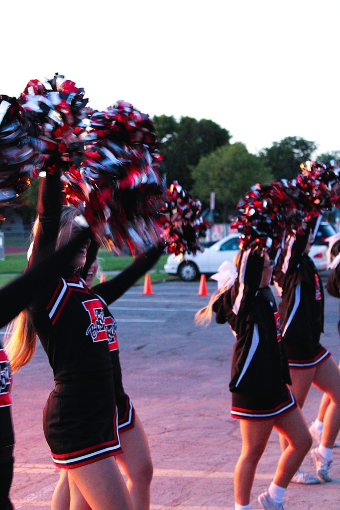 cheerleaders with arms and poms up.