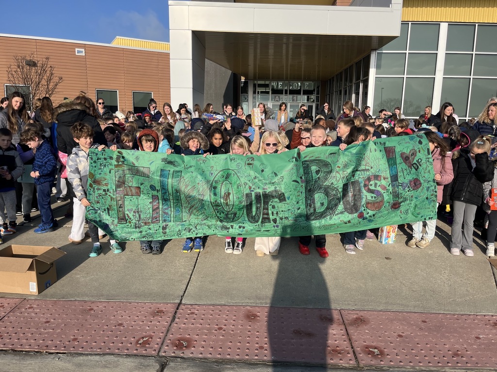 Students holding a "Fill our Bus" sign.