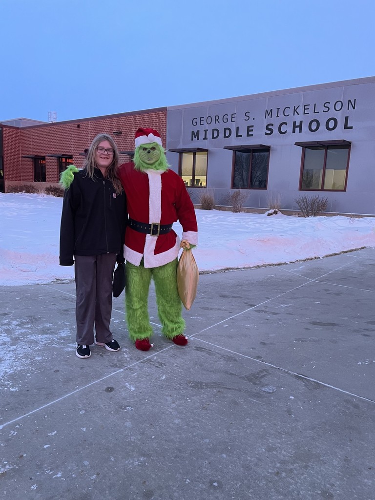 Student posing with a staff member dressed up as The Grinch. 