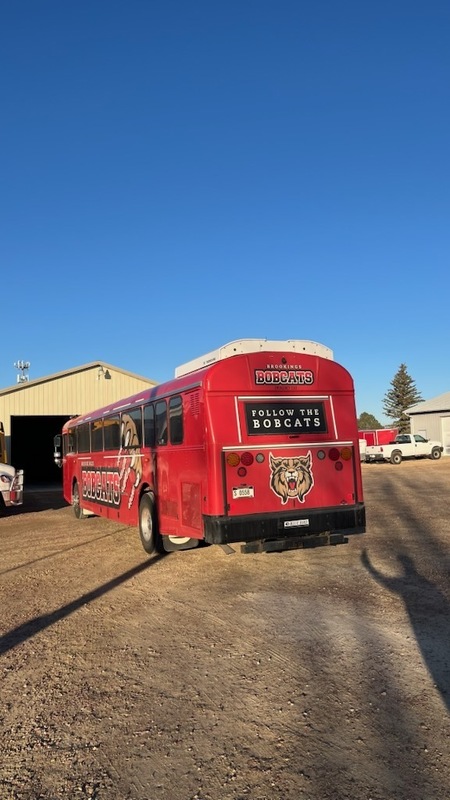 Back of the bus with "follow the bobcats" on it.