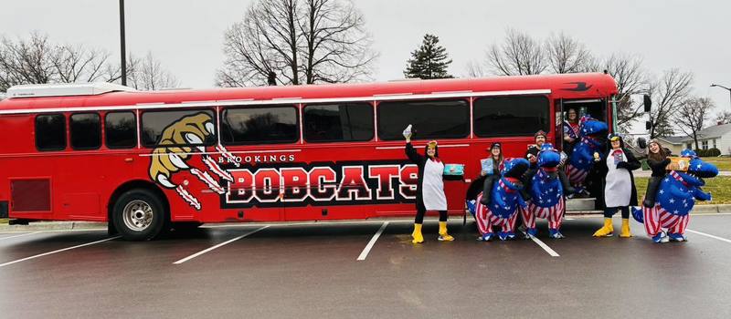 Staff dressed in costumes in front of the bus.