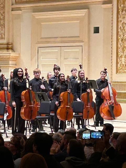 Elizabeth on stage with other performers, smiling.