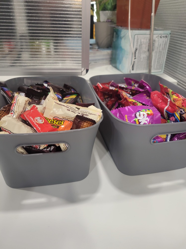 Two small grey buckets with various candies.