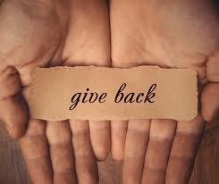 Give back written on brown paper in open hands