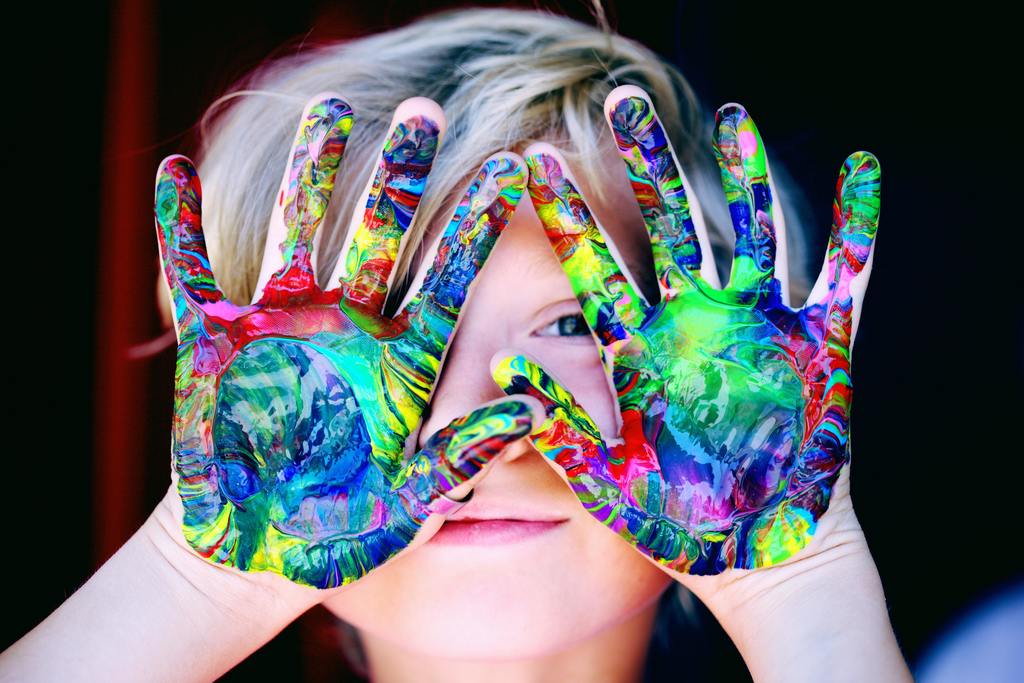 child with finger paint on their hands