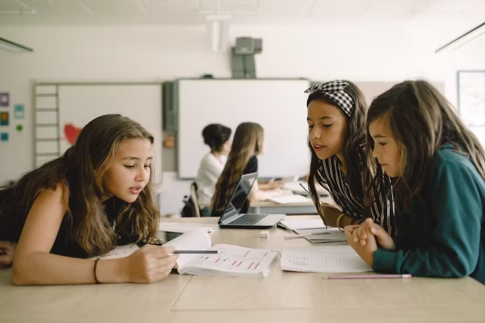Students in a classroom chatting about a current project