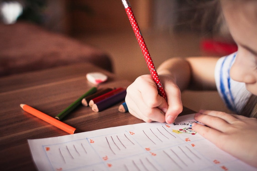 student using red pencil to fill out a handout