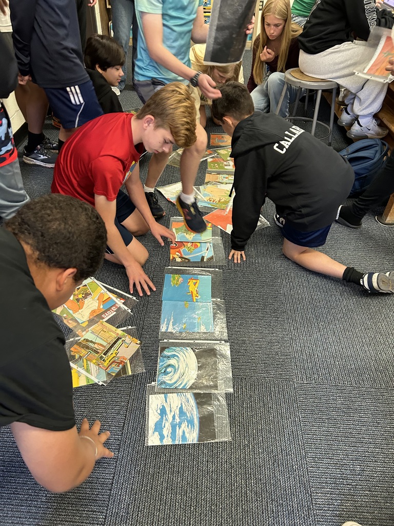 Students on floor sorting pictures.