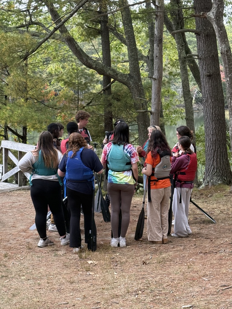 Students in a circle outside receiving instruction.