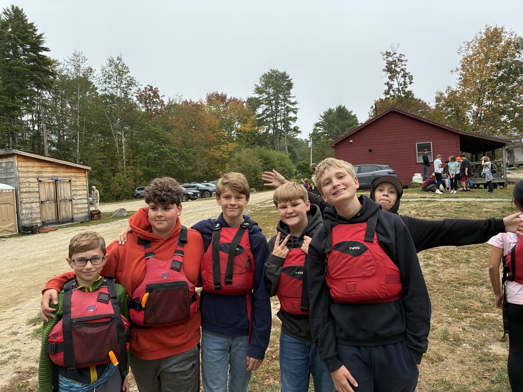 Student posing for a picture wearing lifejackets.