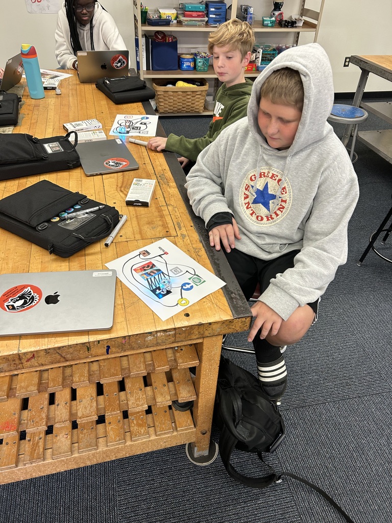 Two student sitting at a table using robots.