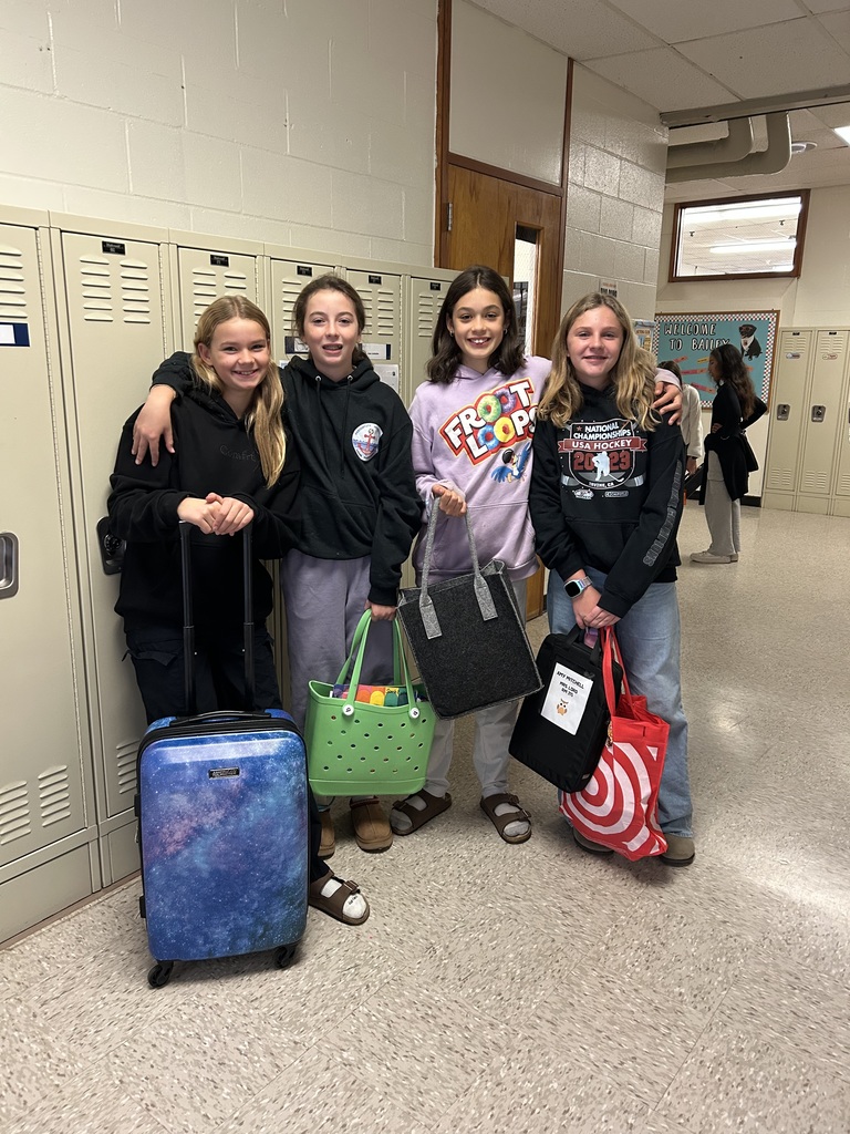 Students posing in a school hallway with unique bags as backpacks.