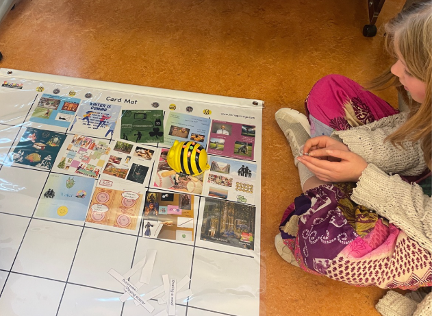 girl watching her Bee-Bot run its code