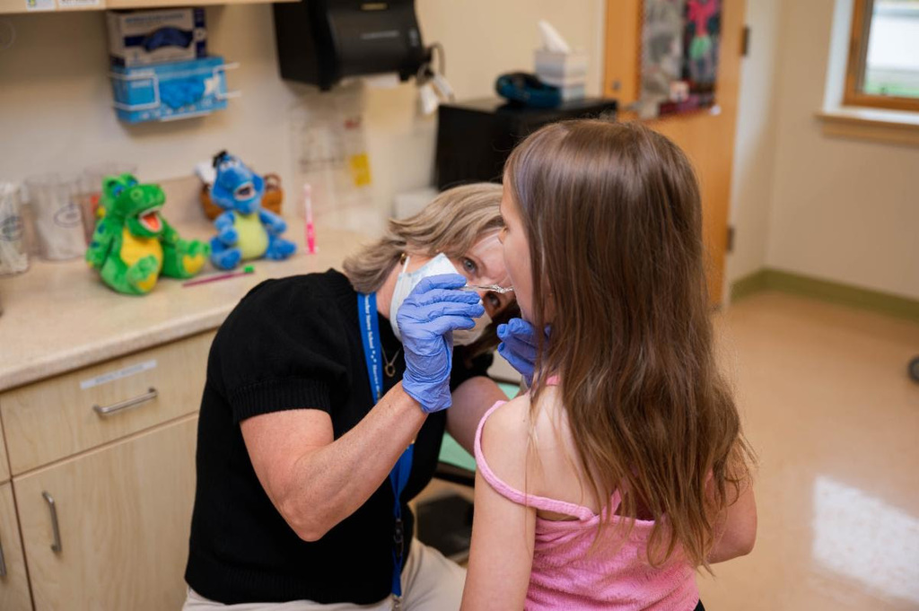 Nurse applying flouride to student