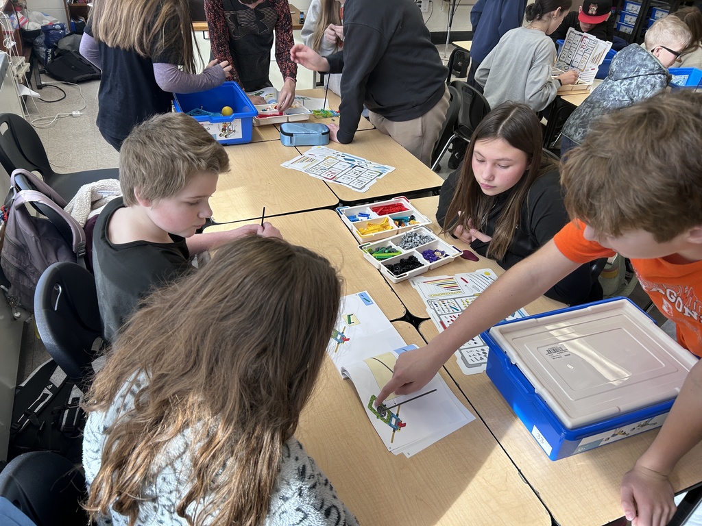 Students sitting around a table building with LEGO's
