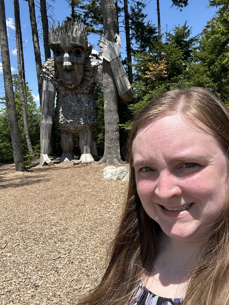 lady with long hair on right side of photo with Giant Troll in background at Botanical Gardens