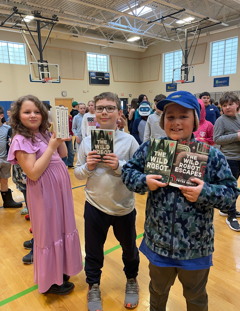 3 students holding their copies of The Wild Robot to get signed