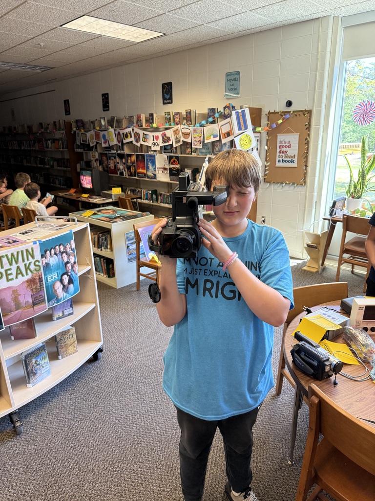 Student using a handheld video camera from the 90's.