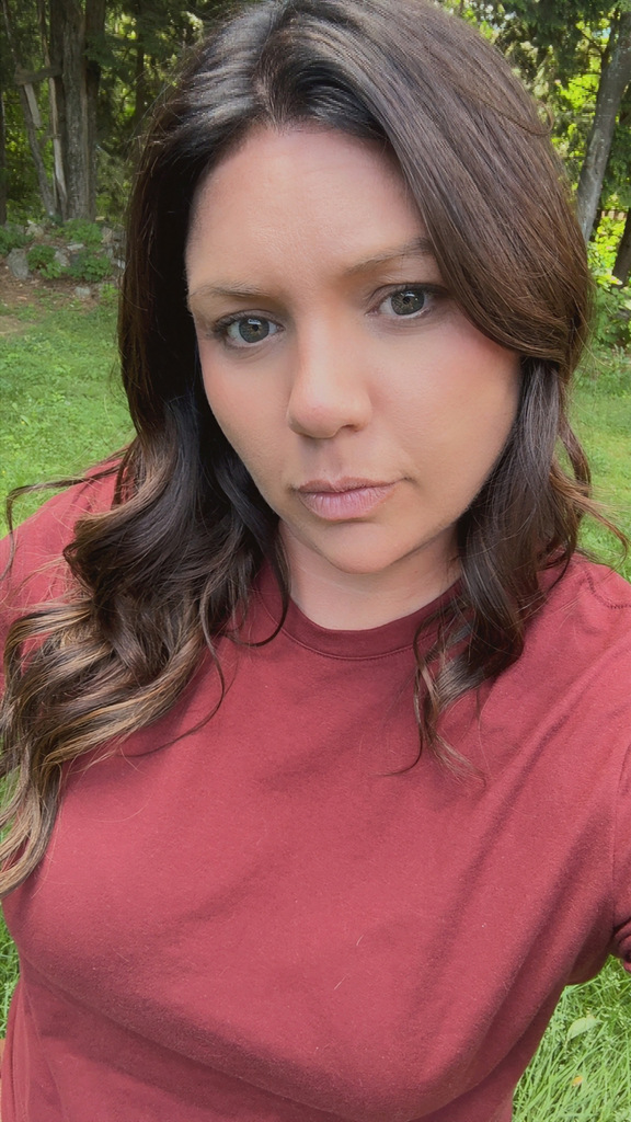 Woman with long dark hair and a maroon shirt.