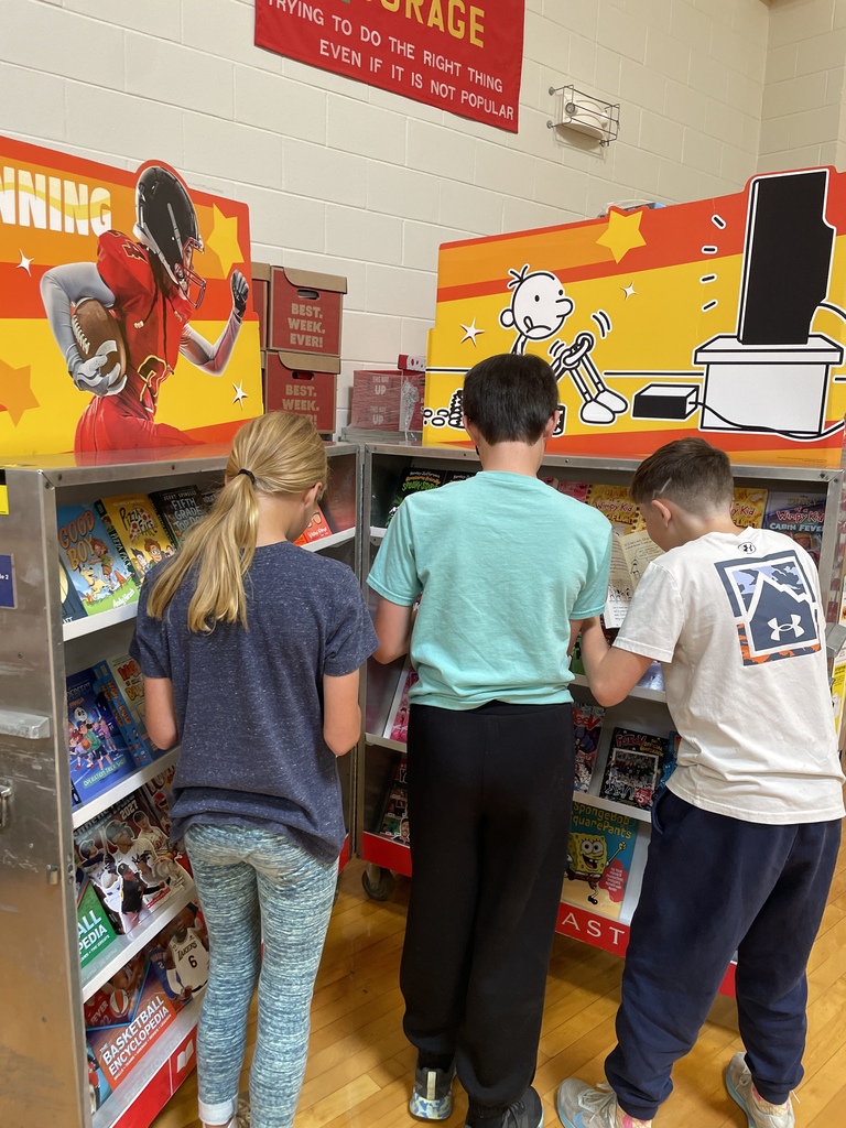 three students looking at books