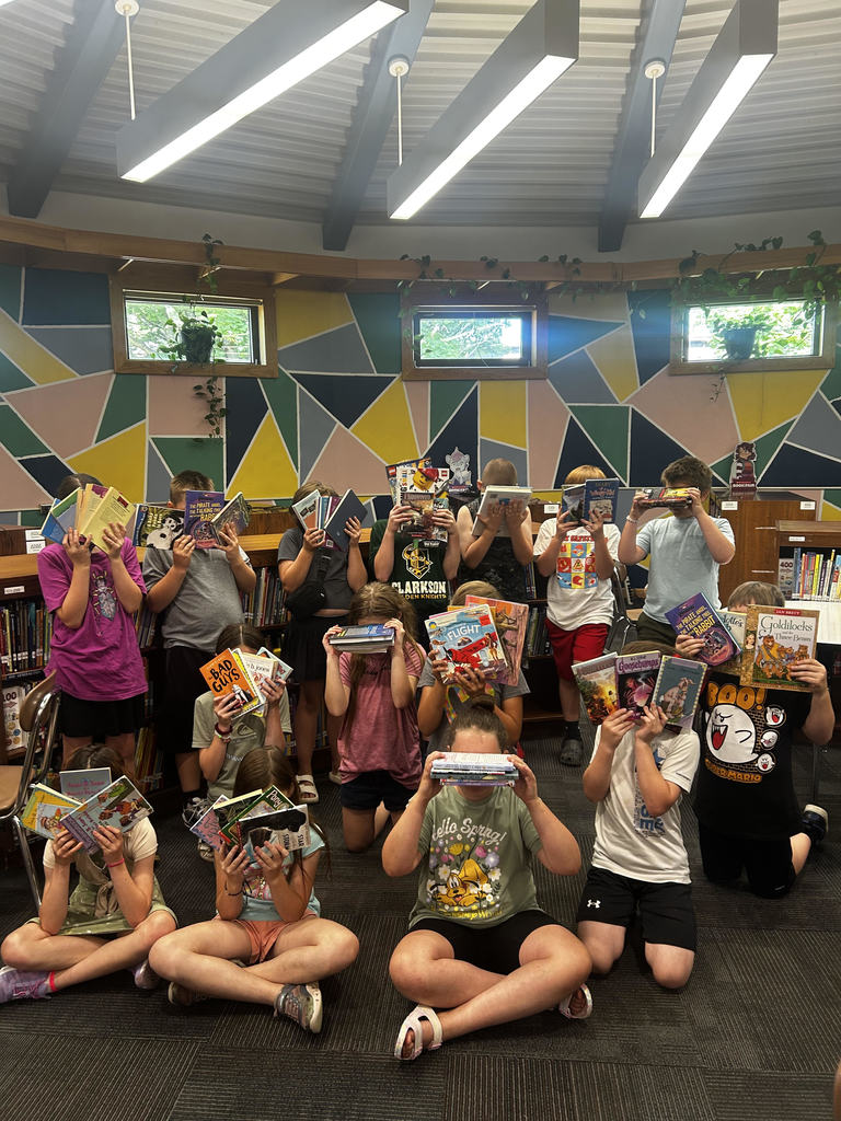 Class with books covering their faces