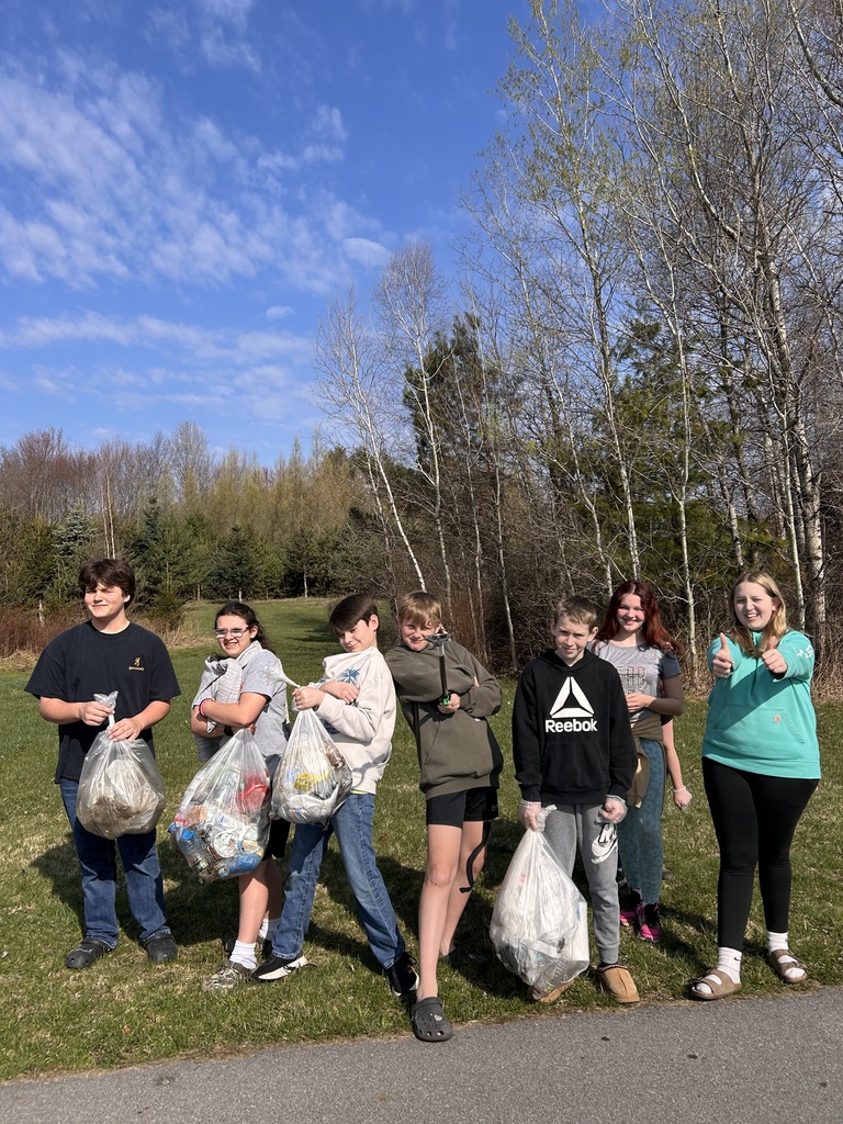 students posing with bags of litter