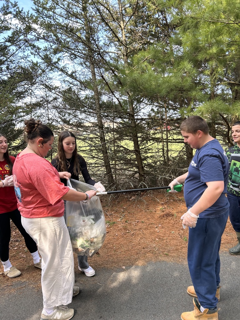 student picking up trash with a grabber