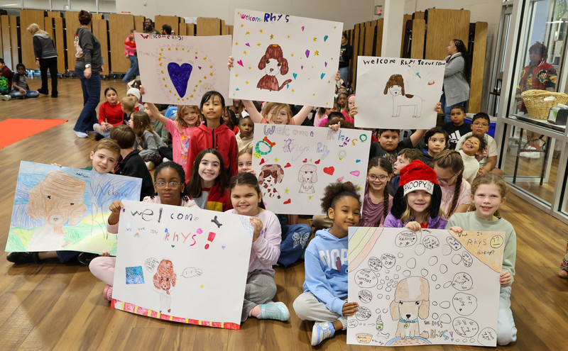 Students holding signs welcoming Rhys.