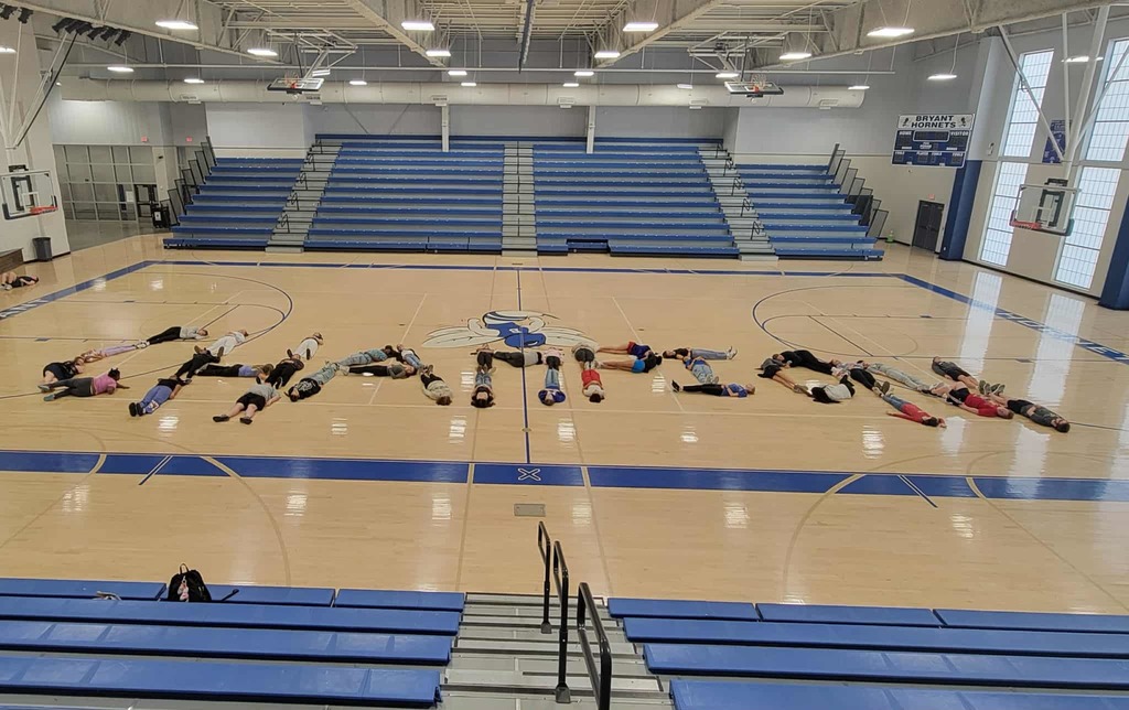 Goldens class laying on the gym floor spelling out champion