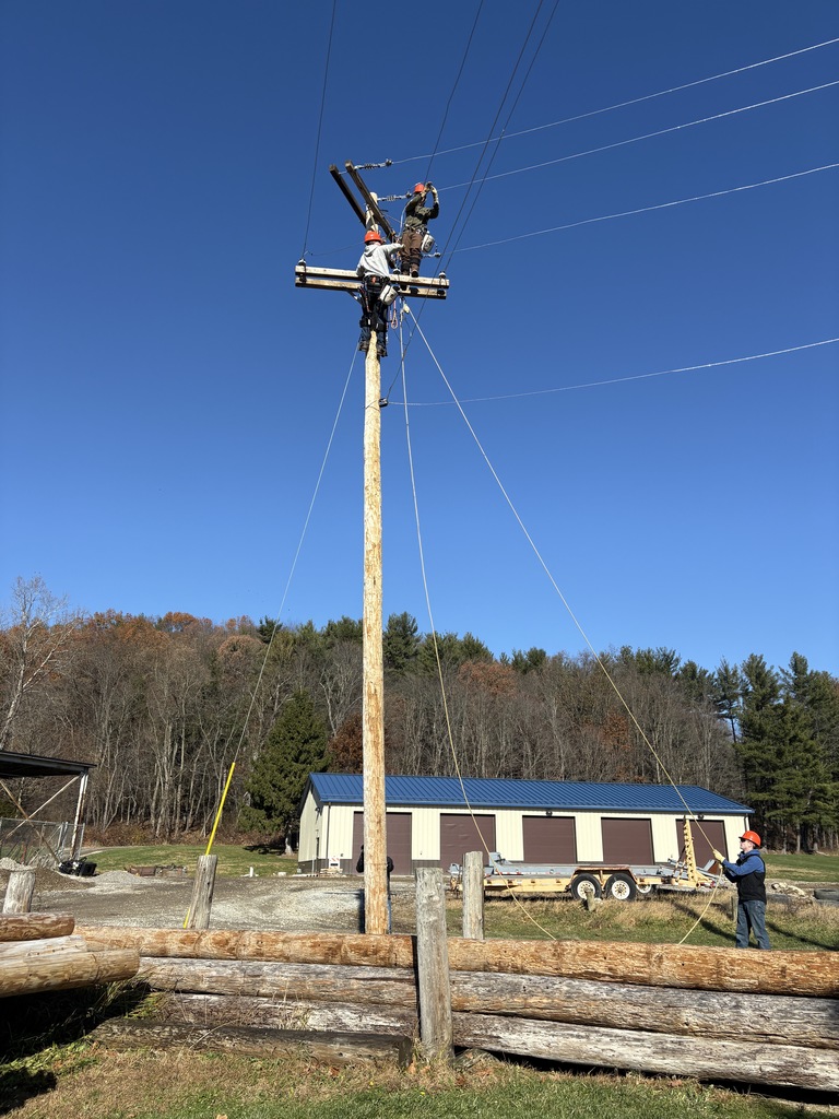 Utility Lineworker climbing poles and connecting conductors.