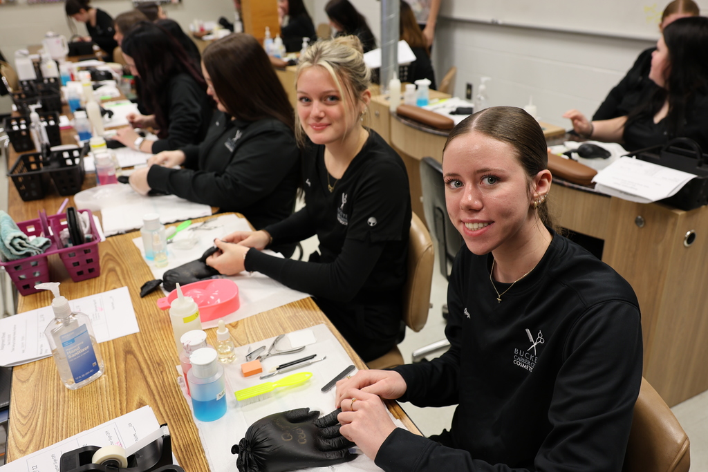 Cosmetology  students working on  painting nails 