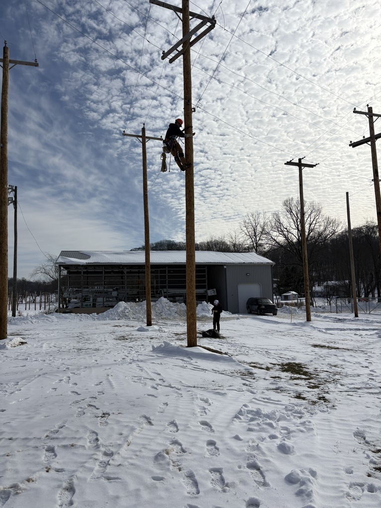 Utility Lineworker climbing poles and connecting conductors.