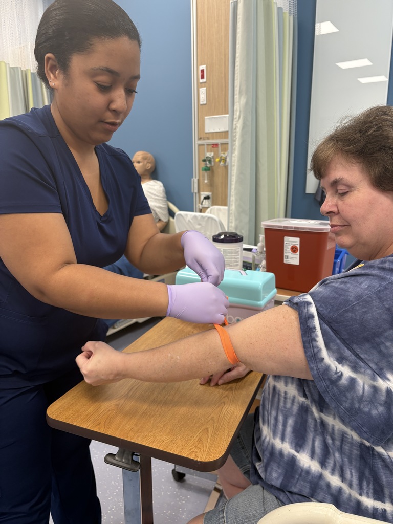 Adult Education Phlebotomy students  are practicing venipuncture on volunteers.