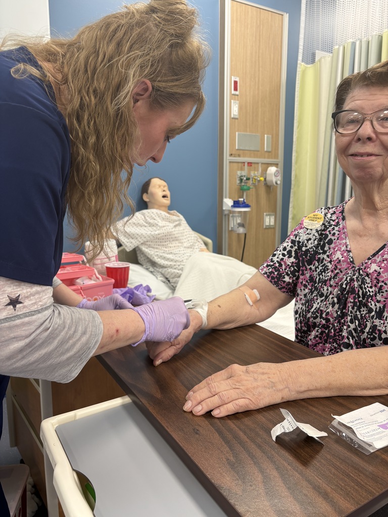 Adult Education Phlebotomy students  are practicing venipuncture on volunteers.