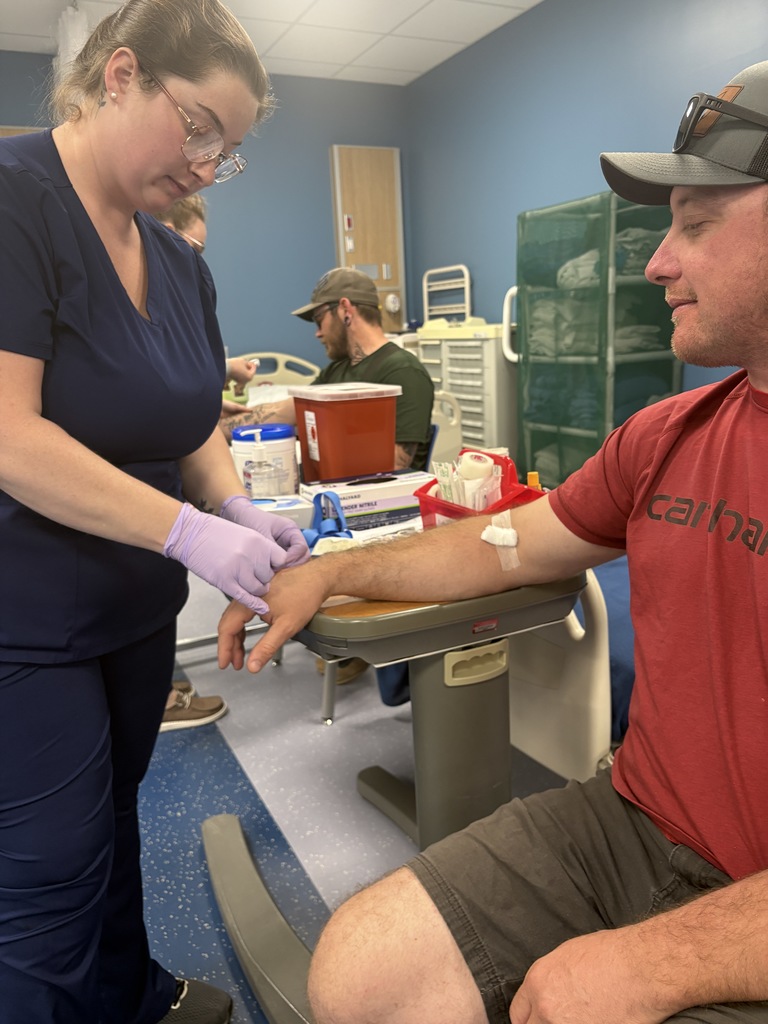 Adult Education Phlebotomy students  are practicing venipuncture on volunteers.