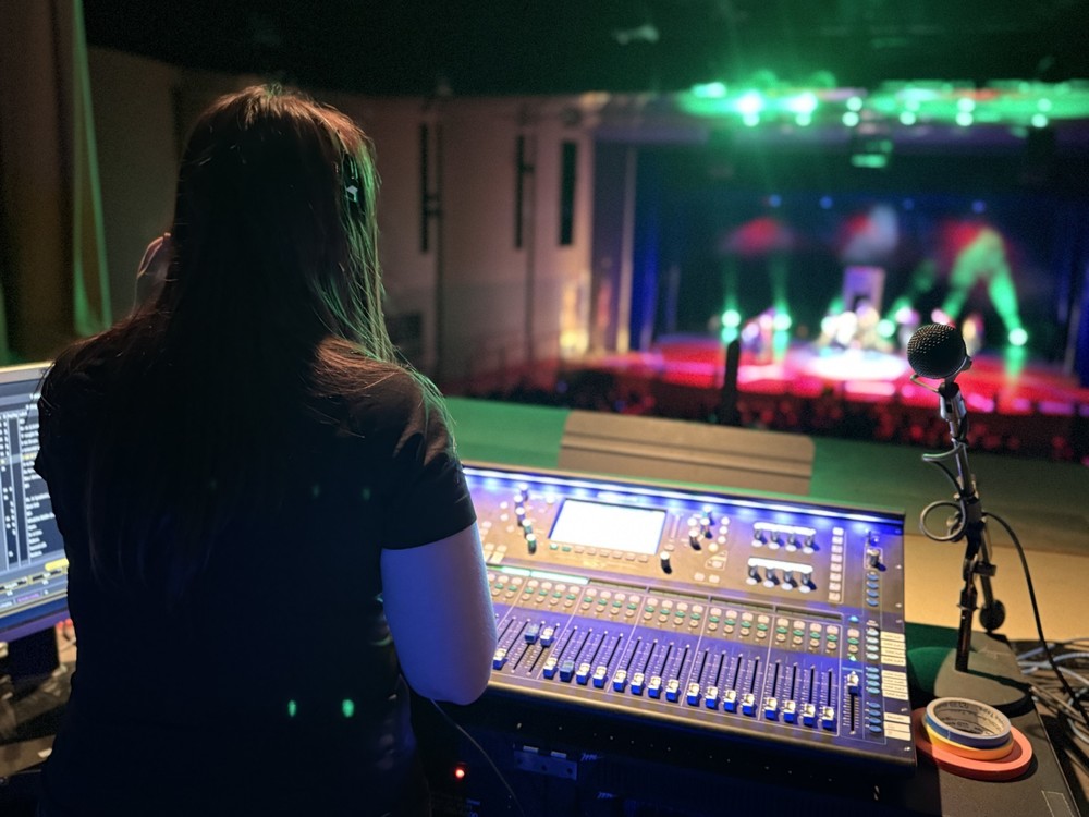 Student running lights for dance show
