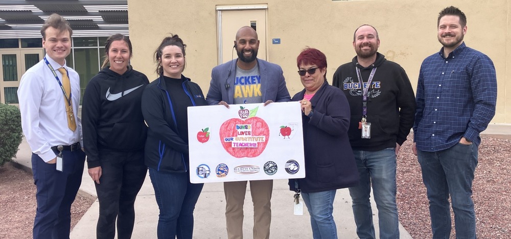 School employees holding substitute appreciation sign