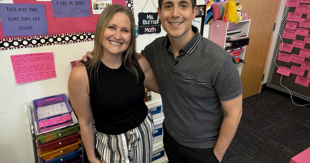 TWO PEOPLE STANDING AND SMILING