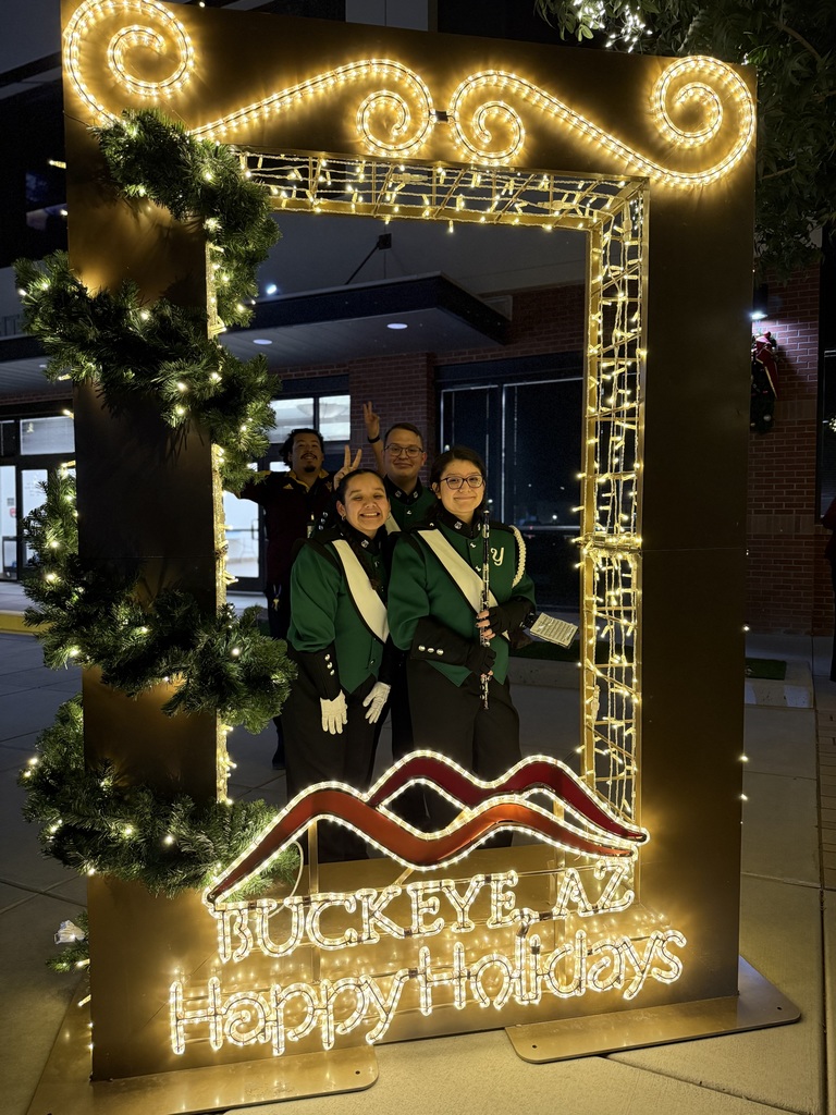 students posing by Christmas light frame